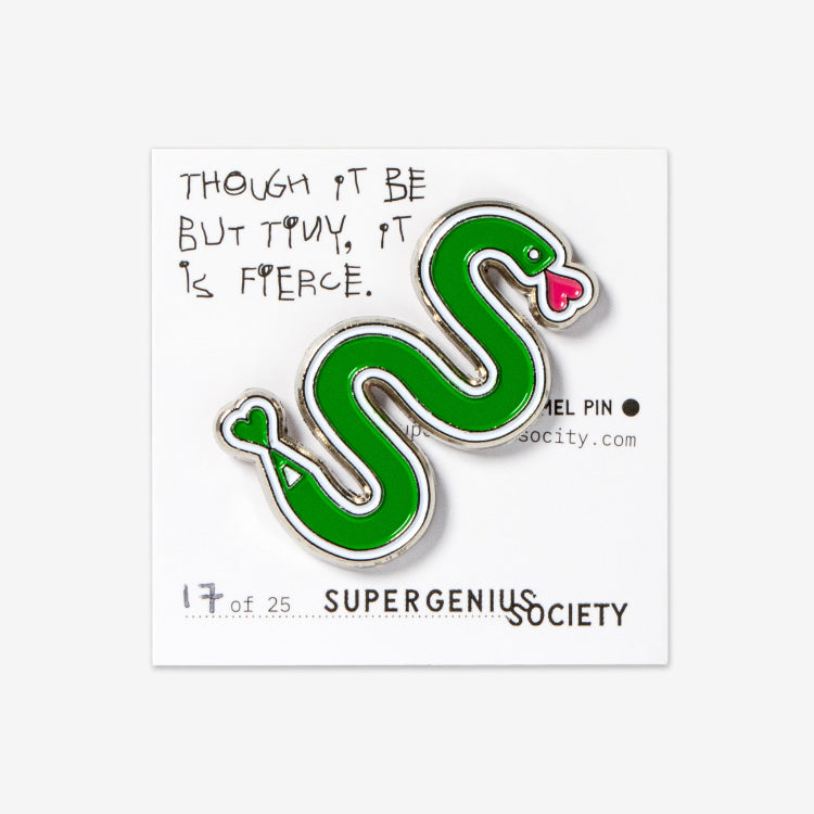 An enamel pin with a green snake design and a white double scribble on a pin backing card with the Super Genius Society branding.