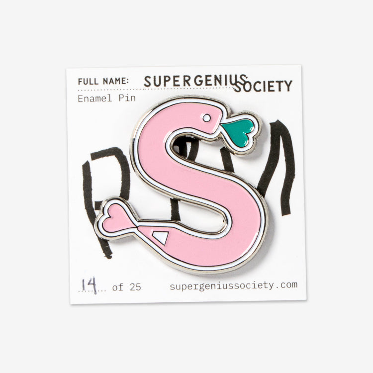 A pink enamel pin with a stylized scribble design that resembles a snake with a heart and a pencil tip, from Super Genius Society.
