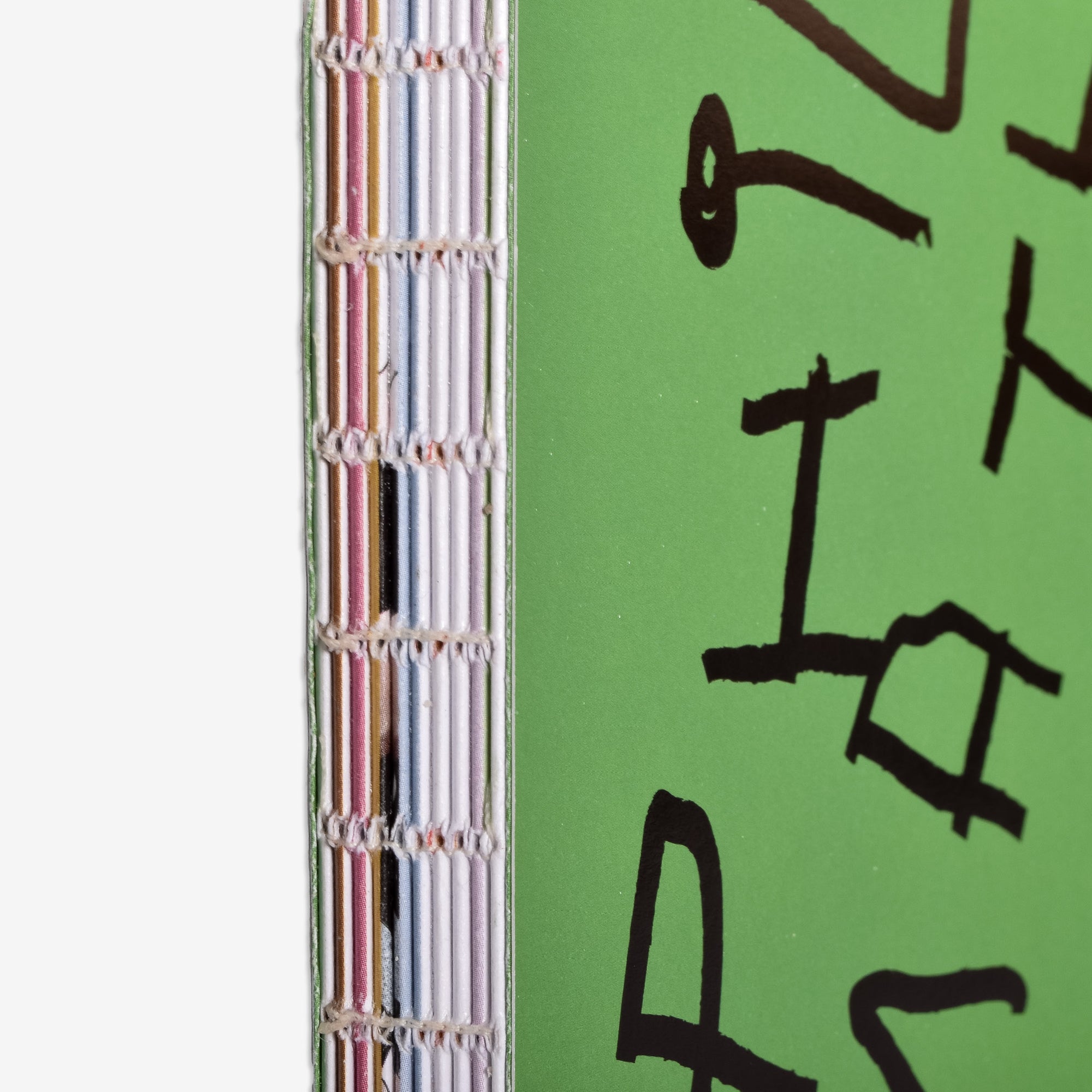 Close-up of a the Philomathy book with colorful exposed smythe binding  spine and black foiled text on a green cover