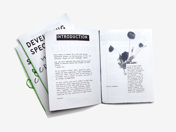 The introduction spread of Developing Specifically Human Capacities with a quote by Martha Nussbaum and two more copies of the zine below bound with green thread