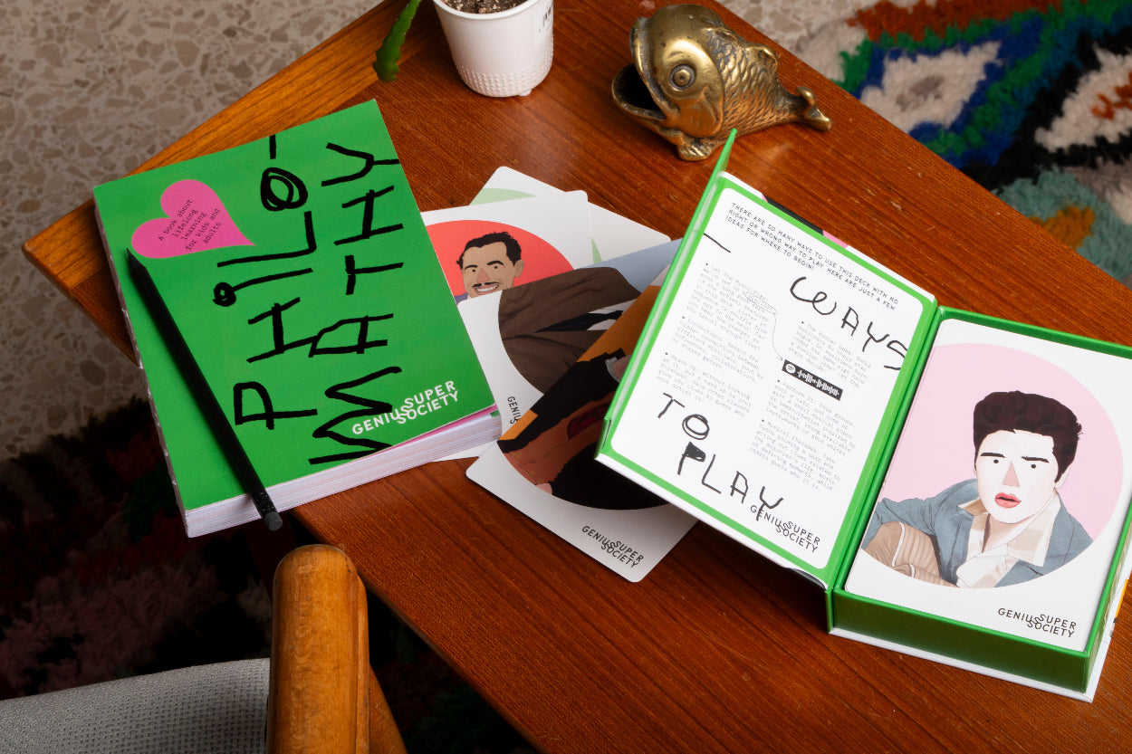 Philomathy book and an open box for Music Vol. 1 deck of music history cards on a wooden table with a casual warm setting